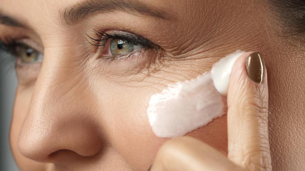 Image of a woman applying cream to her face.